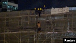 一名抗议者从太古广场大楼周围的施工脚手架上掉下来，当时消防队员正试图营救他。（2019年6月15日）。