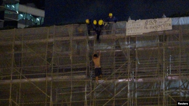一名抗議者從太古廣場大樓周圍的施工腳手架上掉下來，當時消防隊員正試圖營救他。（2019年6月15日）。