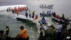 This photo released by Indonesia's National Rescue Team shows rescuers at the crash site of a Lion Air plane in Bali, Indonesia, Apr. 13, 2013. 