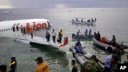 Cảnh cảnh sát và nhân viên cứu hộ dùng xuồng cứu sinh sơ tán hành khách trên chiếc máy bay Boeing 737, do hãng hàng không giá rẻ Lion Air điều hành, ngày 13/4/2013. 