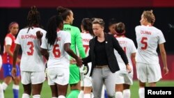 La coach de football féminin du Canada, Bev Priestman, serre la main de ses joueuses après un match lors des Jeux olympiques de Tokyo 2020 à Sapporo, au Japon - 24 juillet 2021. 