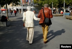 Elderly people walk in the street, ahead of a national vote on pensions reform, in Lausanne, Switzerland, Sept. 22, 2017.