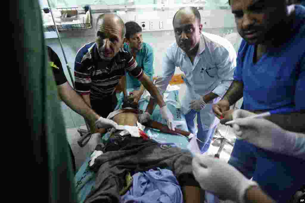 Palestinian medics treat a child wounded in an Israeli strike on a compound housing a U.N. school in Beit Hanoun, in the northern Gaza Strip, at the emergency room of the Kamal Adwan hospital in Beit Lahiya, July 24, 2014.