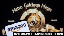 Smartphone with Amazon logo is seen in front of displayed MGM logo in this illustration taken, May 26, 2021. (REUTERS/Dado Ruvic/Illustration)