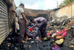 Warga memeriksa puing-puing pasca kebakaran di pasar darurat di dekat kamp pengungsi Rohingya di Kutupalong, Bangladesh, Jumat, 2 April 2021.