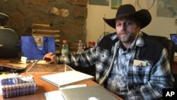 ທ້າວ Ammon Bundy ທີ່ເຫັນນັ່ງຢູ່ໂຕະ ທີ່ສູນກາງຮັກສາສັດປ່າ Malheur ໃນລັດ Oregon.