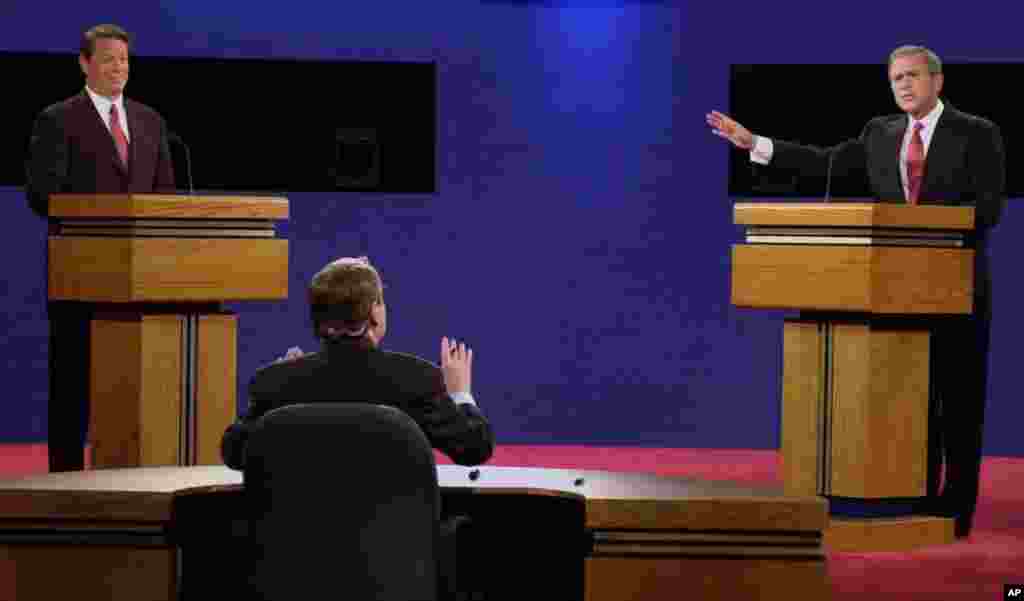 Moderator Jim Lehrer tells Republican presidential candidate Texas Gov. George W. Bush, right, that the candidates made the rules as Democratic presidential candidate Vice President Al Gore listens at the first presidential debate, Oct. 3, 2000, at the Clark Athletic Center on the campus of the University of Massachusetts in Boston.