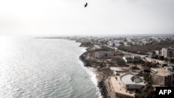 Des gens se baignent sur les plages populaires des Mammelles, devant des chantiers à Dakar, le 27 juin 2020.