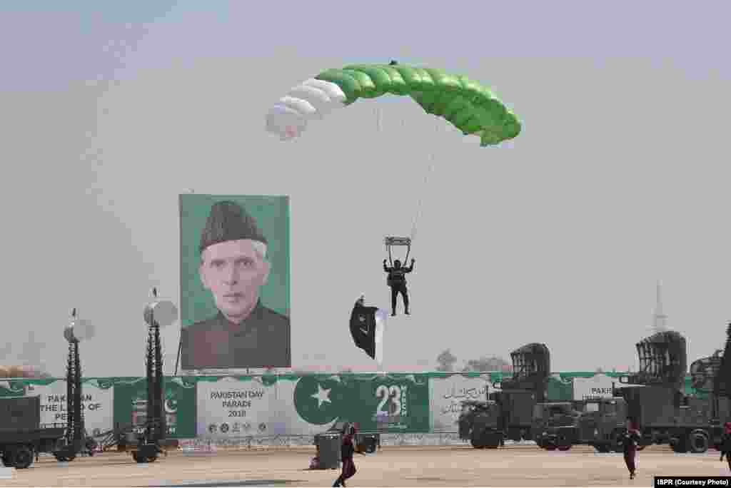 پریڈ میں شامل ایک پیراٹروپر زمین پر اتر رہا ہے