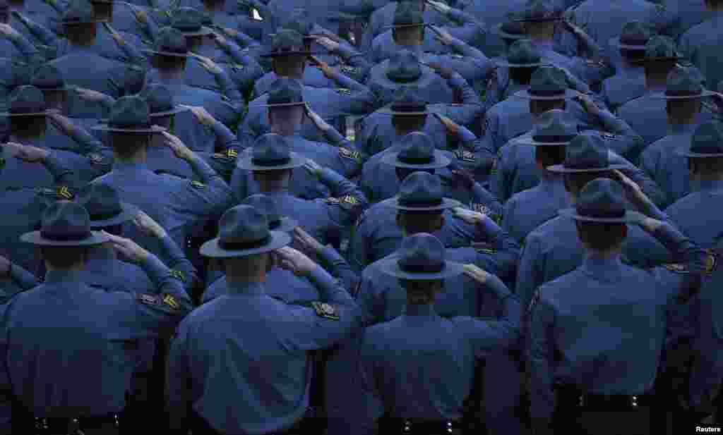 Pennsylvania State Police salute outside St. Peters&#39; Cathedral in Scranton, Pennsylvania, USA, as the casket carrying slain State Police Corporal Bryon Dickson, 38, is carried into the cathedral for his funeral service. The survivalist suspected of the ambush attack last week that killed Dickson and seriously wounded another is a member of a Cold War re-enactment group, state police said. 