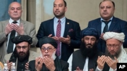 FILE - Taliban political chief Sher Muhammad Abbas Stanikzai, in the first row, second from left, Abdul Salam Hanafi and other Taliban officials pray during the intra-Afghan talks in Moscow, Feb. 6, 2019. 