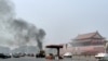 FILE - Vehicles travel along Chang'an Avenue as smoke raises in front of a portrait of late Chinese Chairman Mao Zedong at Tiananmen Square in Beijing, Oct. 28, 2013.