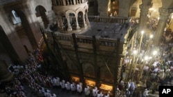 Catholic clergy carry palm fronds during the Palm Sunday procession in the Church of the Holy Sepulcher in Jerusalem's Old City, April 17, 2011
