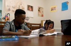 Jacoby Brown (11, kiri) dan saudara perempuannya (9), belajar matematika di rumah mereka di Austin, Texas, Selasa, 13 Juli 2021. (AP)