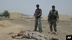 Afghan National Army (ANA) soldiers stand guard near the body of a suicide attacker near US military camp Salerno on the outskirts of Khost city, 28 Aug 2010