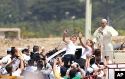 FILE - Pope Francis waves to the crowd as he rides in the popemobile through Samanes Park, where he will celebrate Mass, in Guayaquil, Ecuador, July 6, 2015.
