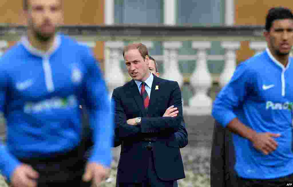 Britains Prince William looks on as Polytechnic FC (In Blue) play Civil Service FC in a Southern Amateur League football match in the grounds of Buckingham Palace, in central London.