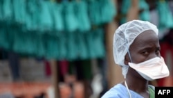FILE - A health worker stands outside the Elwa hospital in Monrovia, Liberia, Sept. 7, 2014, 