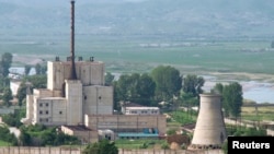 A North Korean nuclear plant is seen before demolishing a cooling tower (R) in Yongbyon, in this photo taken June 27, 2008 and released by Kyodo.