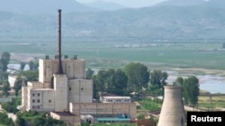 A North Korean nuclear plant is seen before demolishing a cooling tower (R) in Yongbyon, in this photo taken June 27, 2008 and released by Kyodo.
