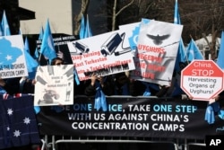 FILE - Uighurs and their supporters rally across the street from United Nations headquarters in New York, March 15, 2018.