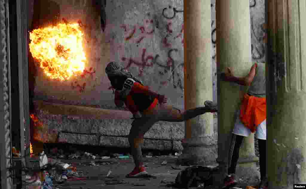 A demonstrator throws a molotov cocktail during ongoing anti-government protests in Baghdad, Iraq.