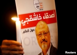 Seorang demonstran memegang poster bergambar wartawan Arab Saudi Jamal Khashoggi di luar Konsulat Istanbul, Turki, 25 Oktober 2018.