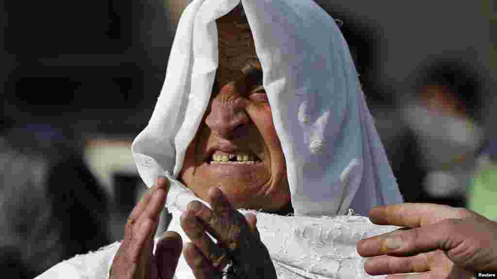 A woman mourns as she looks for her relatives at the site of a suicide attack in Kabul, Afghanistan, Nov. 27, 2014. 