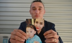 Australian Uighur Sadam Abdusalam holds up a photo of his wife Nadila and their toddler son Lutfi, whom he has never met. He is trying to get them released from China.