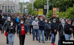 FILE - Opposition supporters wearing protective face masks wait in a line to put signatures in support of their potential candidates in the upcoming presidential election in Minsk, Belarus, May 31, 2020.