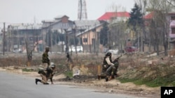 سری نگر میں بدھ کو ہونے والی جھڑپ کے دوران میں بھارتی فوجی اہلکار پوزیشن لے رہے ہیں