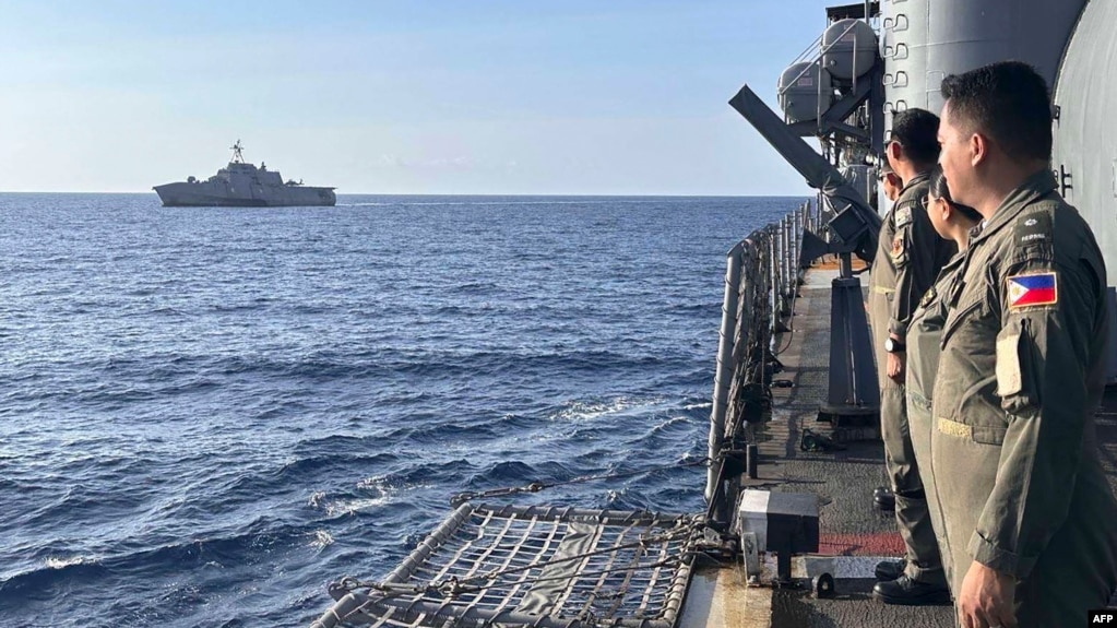 在有争议的南中国海举行的一次海上合作活动期间，菲律宾海军葛雷戈里奥·德尔·皮拉尔级巡防舰上的海军军官向途经的美海军“吉福兹”号濒海战斗舰致意。（2024 年2月9日）(photo:VOA)