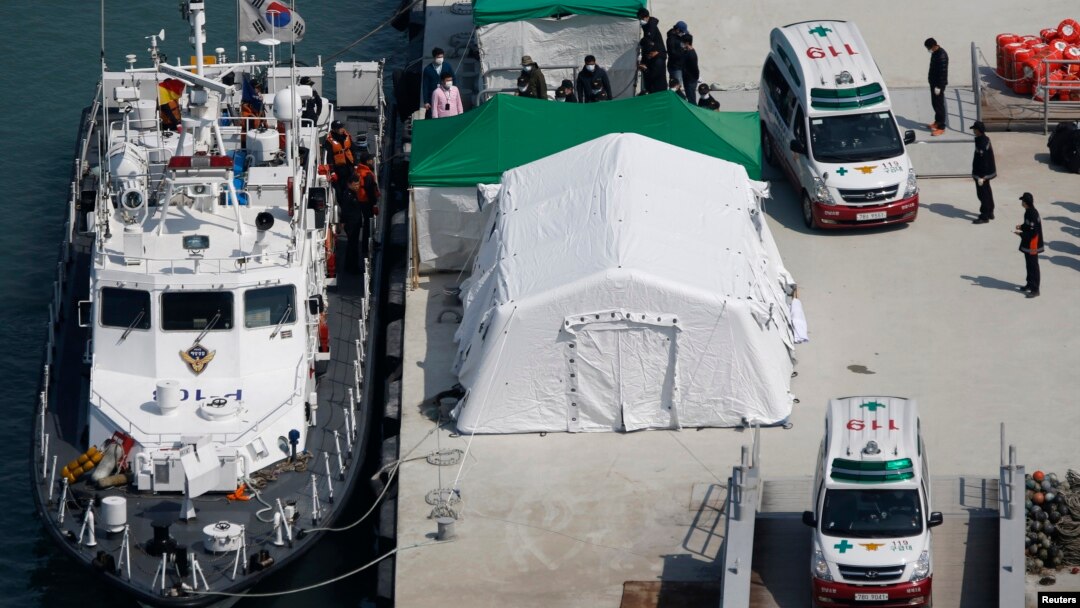 Sebuah ambulans membawa jenazah penumpang kapal tenggelam di pelabuhan Jindo, Korea Selatan (23/4). (Reuters/Issei Kato)