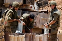 Israeli soldiers check artillery shells in an area near the border with Gaza, in southern Israel, May 13, 2021.