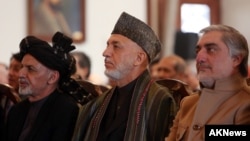 Afghan President Ashraf Ghani, left, former President Hamid Karzai, center, and Chief Executive Abdullah Abdullah, right, attend a ceremony marking the completion of security transition to Afghan security forces in Kabul, Jan. 1, 2015. 