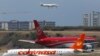 FILE - Airplanes wait their turn to take off on a runway of the Simon Bolivar airport in La Guaira, outside Caracas, Sept. 23, 2013.