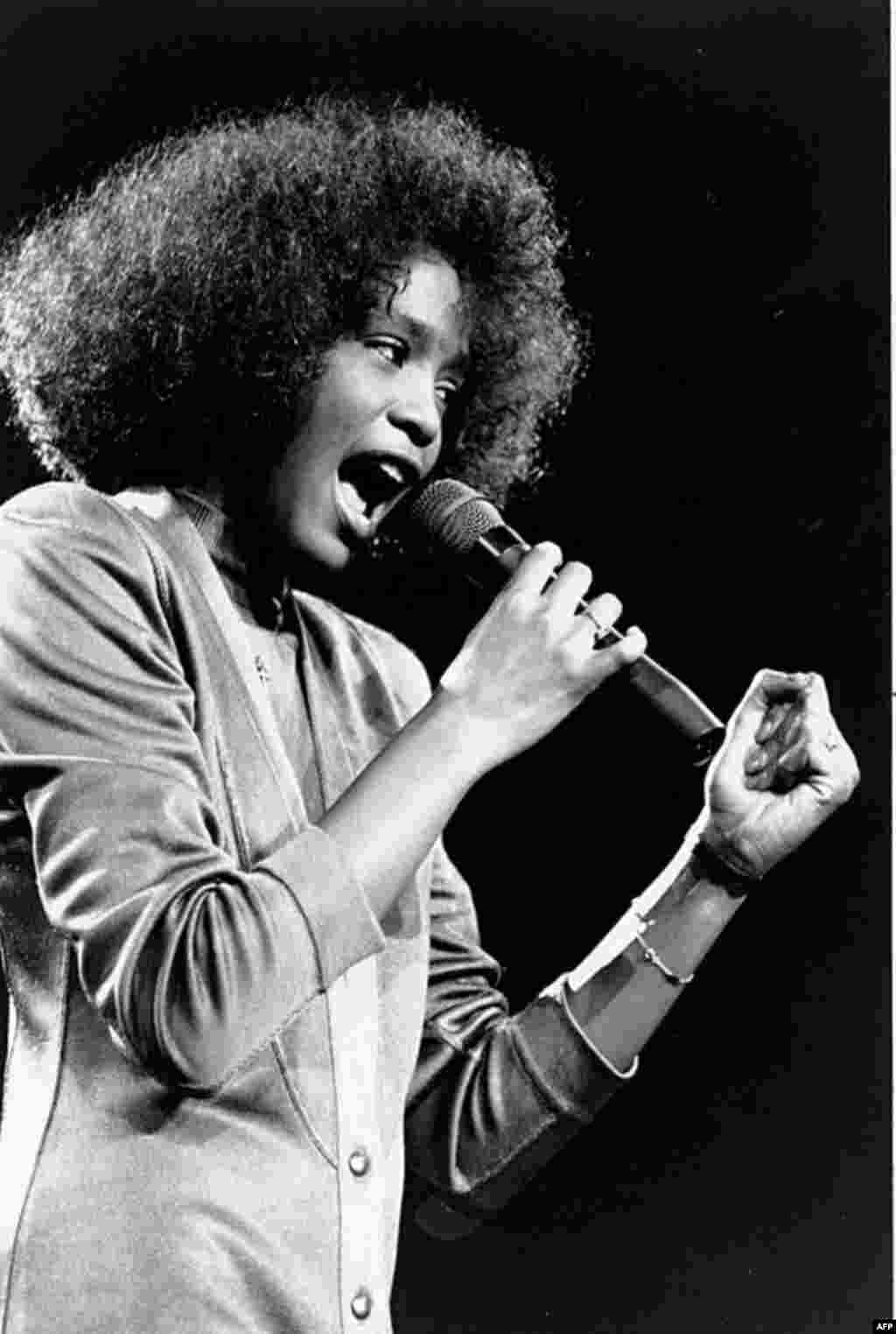 In this May 10, 1986 photo, American singer Whitney Houston sings during a benefit concert at Boston Garden. Houston died February 11, 2012, at age 48. (AP)