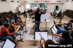 A string orchestra, part of an initiative to promote equity in classical music, rehearses at New Hope Presbyterian Church on Wednesday, Oct. 16, 2024, in Anaheim, California. (AP Photo/William Liang)