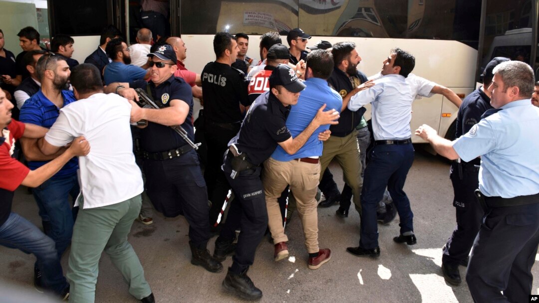 FILE - Police officers try to stop people attacking a judge believed to be member of a coup plotter group in Erzurum, Turkey, July 19, 2016. 