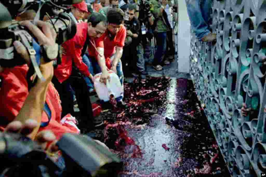 Red-shirted supporters of deposed Thai premier Thaksin Shinawatra pour alleged human blood during a demonstration in Bangkok on March 16, 2010.