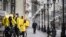 A man walks along pedestrian Arbat street as food delivery couriers talk to each other, in downtown Moscow, April 14, 2020. 