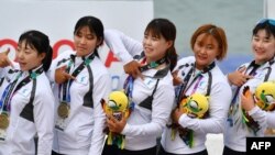 Anggota tim gabungan Korea berpose di podium setelah memenangkan medali perunggu untuk nomor final perahu naga 200-meter putri Asian Games di Palembang, 25 Agustus 2018. 