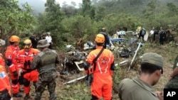 Petugas pemadam kebakaran dan tentara memeriksa lokasi jatuhnya helikopter di Huehuetenango, Guatemala, dekat perbatasan Meksiko. (AP/Guatemalan Volunteer Fire Department)