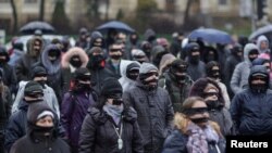 Romanians sporting black cloths over their mouths and eyes protest against the ruling leftist Social Democrat party plans to overhaul judicial legislation in Bucharest, Dec. 17, 2017.