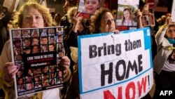 Protesters lift placards during a rally outside the Unicef offices in Tel Aviv on November 20, 2023 to demand the release of Israelis held hostage in Gaza since the October 7 attack by Hamas militants. 