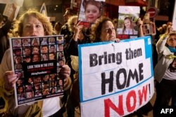 Para pengunjuk menuntut pembebasan warga Israel yang disandera di Gaza sejak 7 Oktober di luar kantor Unicef di Tel Aviv pada 20 November 2023. (Foto: AFP)