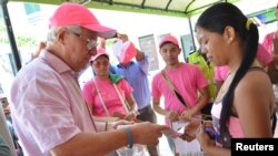 Walikota Soledad Joao Herrera (kiri) memberikan paket kesehatan dalam kampanye mengatasi penyebaran virus Zika di Soledad dekat Barranquilla, Kolombia, 1 Februari 2016.