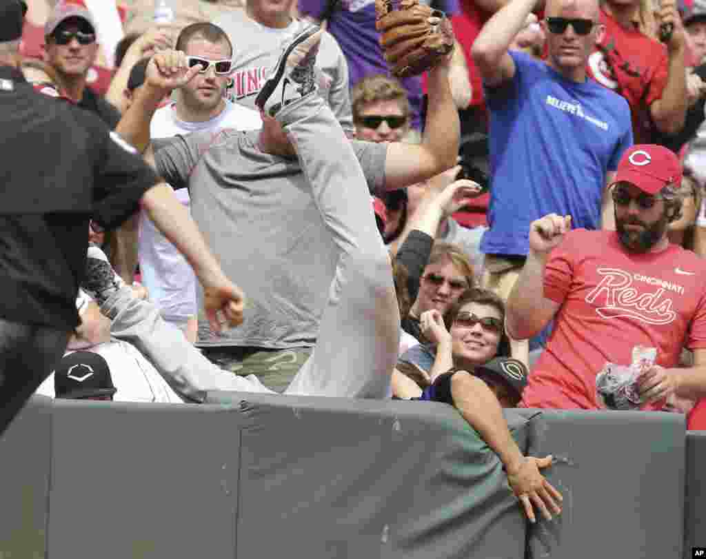 Colorado Rockies&#39; third baseman Nolan Arenado falls into the stands after catching a foul ball off the bat of Cincinnati Reds&#39; Zack Cozart during the eighth inning of a baseball game in Cincinnati, Ohio, USA, May 25, 2015. The Rockies won 5-4.