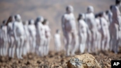 Personas posan desnudas para el artista estadounidense Spencer Tunick como parte de una instalación en el desierto cerca del Mar Muerto, en Arad, Israel, el domingo 17 de octubre de 2021. Unos 300 personas participaron en la instalación. (AP/Ariel Schalit)