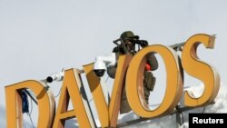 A police officer uses binoculars on a roof, ahead of the annual meeting of the World Economic Forum in Davos, Switzerland, January 15, 2024.